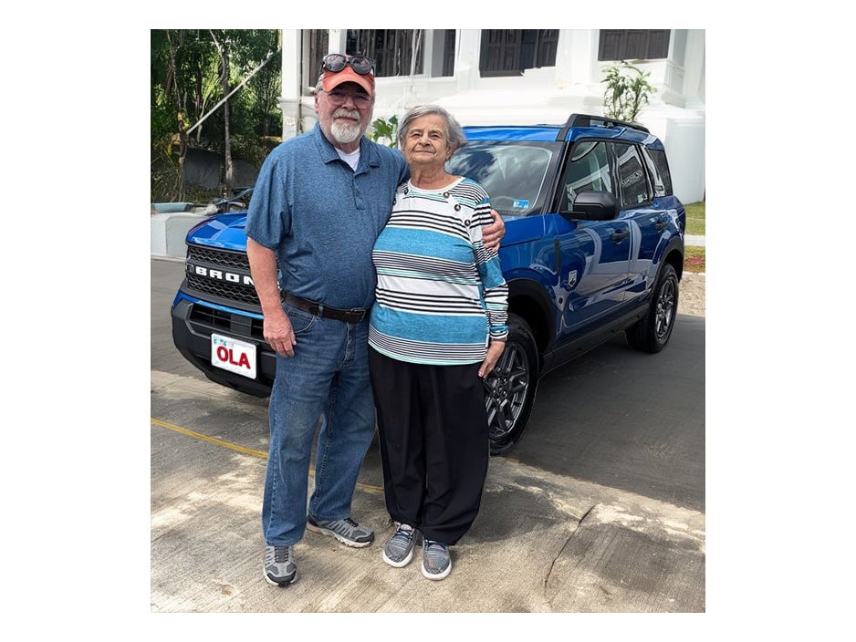 Two parishioners standing in front of the Ford Bronco won in the parish car raffle
